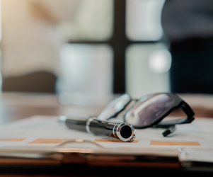 Pair of glasses and pen on table